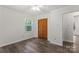 Neutral bedroom featuring hardwood floors, a closet, and a window with wooded view at 3943 Peggy Ln, Mint Hill, NC 28227