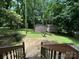 Spacious backyard with mature trees, sheds for storage, and a stone patio at 407 Alton St, Monroe, NC 28110