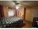 Cozy bedroom with a floral comforter, hardwood floors, and a ceiling fan at 407 Alton St, Monroe, NC 28110