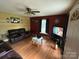 Relaxing living room featuring a ceiling fan, hardwood floors, a window, and a comfortable couch at 407 Alton St, Monroe, NC 28110