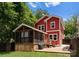 Back exterior of a two-story red house with a screened-in porch, patio, grill, and lounge chairs at 423 Solomon St, Charlotte, NC 28216