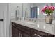 Bathroom vanity features granite counters, chrome faucet, gray walls, and is decorated with a vase of flowers at 423 Solomon St, Charlotte, NC 28216