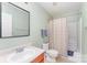 Standard bathroom with a toilet, sink, mirror, and shower with beige colored walls at 4462 Kellybrook Dr, Concord, NC 28025