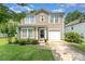 Charming two-story home featuring a well-manicured lawn, tidy landscaping, and a one-car garage at 4462 Kellybrook Dr, Concord, NC 28025