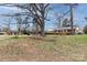 A quaint brick home nestled among mature trees, blending classic charm with natural surroundings at 4601 Mendham Dr, Charlotte, NC 28215