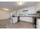Bright kitchen featuring white cabinets and stainless appliances, open to living area at 4601 Mendham Dr, Charlotte, NC 28215