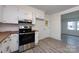 Spacious kitchen with stainless steel appliances and new flooring open to a living area at 4601 Mendham Dr, Charlotte, NC 28215