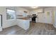 Galley kitchen with white cabinetry and stainless steel oven, new flooring at 4601 Mendham Dr, Charlotte, NC 28215