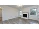 Cozy living room featuring white brick fireplace, ample windows, and new flooring at 4601 Mendham Dr, Charlotte, NC 28215