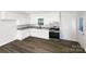 Modern kitchen with white cabinets, granite countertops, stainless steel appliances, and hardwood flooring at 4903 Jamee Dr, Gastonia, NC 28056