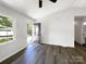 Clean living room featuring wood-look flooring, a large window, and an open doorway to a bedroom at 4903 Jamee Dr, Gastonia, NC 28056