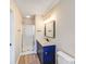 Bathroom featuring a shower, modern vanity with gold hardware, and vinyl flooring at 5417 Timbertop Ln, Charlotte, NC 28215
