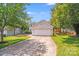 Home exterior with a two-car garage and a large driveway surrounded by lush trees at 5417 Timbertop Ln, Charlotte, NC 28215