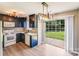 Modern kitchen with navy cabinets, stainless steel appliances, and a sliding glass door for outdoor access at 5417 Timbertop Ln, Charlotte, NC 28215