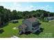 Aerial view showcasing a two-story home, large yard, outbuilding, and surrounding trees at 550 Baker Mill Rd, Cleveland, NC 27013