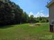 Large backyard with mature trees and an outbuilding, perfect for outdoor activities at 550 Baker Mill Rd, Cleveland, NC 27013