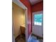 Half bathroom with a mirrored vanity next to an exterior door and red accent wall at 550 Baker Mill Rd, Cleveland, NC 27013