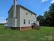 Back exterior of a two-story home with a chimney, stairs to deck and grassy yard at 550 Baker Mill Rd, Cleveland, NC 27013