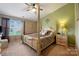 Spacious main bedroom featuring a four-poster bed, ceiling fan, and a cozy ambiance at 6340 Ziegler Ln # 148-A, Charlotte, NC 28269
