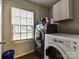 Functional laundry room equipped with a washer, dryer, and overhead storage, designed for convenience at 7024 Sunman Rd, Charlotte, NC 28216