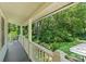 A covered back porch, including a chair, looking out onto a lush green lawn with trees at 747 9Th Nw St, Hickory, NC 28601