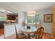 Sunny dining room with a round table, hardwood floors, bright windows, and white wood paneling at 747 9Th Nw St, Hickory, NC 28601