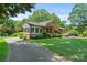 Exterior side view of a beautiful brick home with a well-kept lawn and a cozy sunroom at 747 9Th Nw St, Hickory, NC 28601