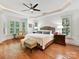 Main bedroom featuring tray ceilings, a ceiling fan, and lots of natural light from the windows at 9000 Whirlaway Ln, Waxhaw, NC 28173