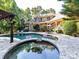 Beautiful backyard with a swimming pool, spa, patio, and lush landscaping, perfect for outdoor enjoyment at 9000 Whirlaway Ln, Waxhaw, NC 28173
