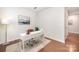 Bright home office with a white desk, natural light, and hardwood floors creating an ideal workspace at 9311 Dunwich Dr, Gastonia, NC 28056
