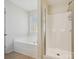 Bright bathroom featuring a soaking tub with glass block window and glass enclosed shower at 10409 Dominion Village Dr, Charlotte, NC 28269