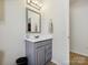 Bathroom showcasing a modern vanity with gray cabinets, mirror, and neutral wall color at 10409 Dominion Village Dr, Charlotte, NC 28269