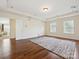 Spacious bedroom with hardwood floors, tray ceiling, and three large windows at 10409 Dominion Village Dr, Charlotte, NC 28269