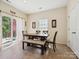 Bright dining area featuring a wooden table, bench seating, and sliding glass doors to outdoor patio at 10409 Dominion Village Dr, Charlotte, NC 28269