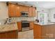 Functional kitchen with stainless steel appliances, granite countertops, and a view into the breakfast area at 10409 Dominion Village Dr, Charlotte, NC 28269