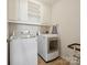 Functional laundry room with washer, dryer, and storage cabinets for convenience at 10409 Dominion Village Dr, Charlotte, NC 28269