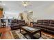Open-concept living room with hardwood floors, comfortable leather sofas, and a staircase in the background at 10409 Dominion Village Dr, Charlotte, NC 28269
