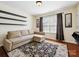 Cozy living room with a comfortable sectional sofa, wood flooring, and a decorative area rug at 10409 Dominion Village Dr, Charlotte, NC 28269