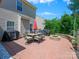 Brick patio includes an outdoor dining set, grill, and fire pit at 10409 Dominion Village Dr, Charlotte, NC 28269