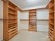 Spacious walk-in closet boasts wood shelving and drawers, offering ample storage solutions at 10409 Dominion Village Dr, Charlotte, NC 28269