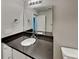 Bathroom vanity features a dark countertop and undermount sink with bright lighting at 115 Dove Sw Ave, Concord, NC 28025