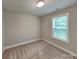 A well-lit bedroom features neutral walls, carpeted floors, and a window for natural light at 115 Dove Sw Ave, Concord, NC 28025