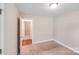 A bedroom with neutral carpet, white trim, and view to another room at 115 Dove Sw Ave, Concord, NC 28025