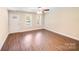 Cozy living room featuring wood-look floors, large windows, a ceiling fan, and a bright entryway at 115 Dove Sw Ave, Concord, NC 28025