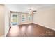 Bright living room with wood-look floors, large windows, a ceiling fan, and access to the outdoor area at 115 Dove Sw Ave, Concord, NC 28025