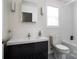 Clean bathroom featuring dark vanity, white tiling, modern finishes, and a window for natural lighting at 12341 Mcallister Park Dr, Charlotte, NC 28277
