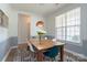 Sunlit dining area featuring a wooden table, blue and white chairs, and a decorative light fixture at 12341 Mcallister Park Dr, Charlotte, NC 28277