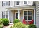 Close up of inviting front porch with black door, bright red chairs, and lush landscaping at 12341 Mcallister Park Dr, Charlotte, NC 28277