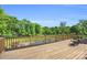 A wooden deck overlooks a stunning pool and lush greenery, offering a tranquil outdoor experience at 1430 Rosehill Dr, Waxhaw, NC 28173