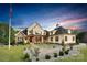 Elegant brick home with a welcoming front porch, manicured lawn, and a picturesque American flag at 1430 Rosehill Dr, Waxhaw, NC 28173